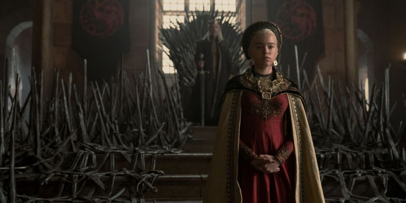   Rhaenyra Targaryen stojící před Železným trůnem v Domě draka